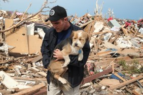 MOORE, OK - MAY 21: Sean Xuereb recovers a dog from the rubble of a home that was destroyed by a tornado on May 21, 2013 in Moore, Oklahoma. The town reported a tornado of at least EF4 strength and two miles wide that touched down yesterday killing at least 24 people and leveling everything in its path. U.S. President Barack Obama promised federal aid to supplement state and local recovery efforts.