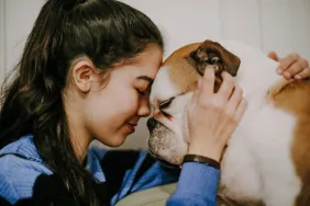 woman showing love to her dog with a hug